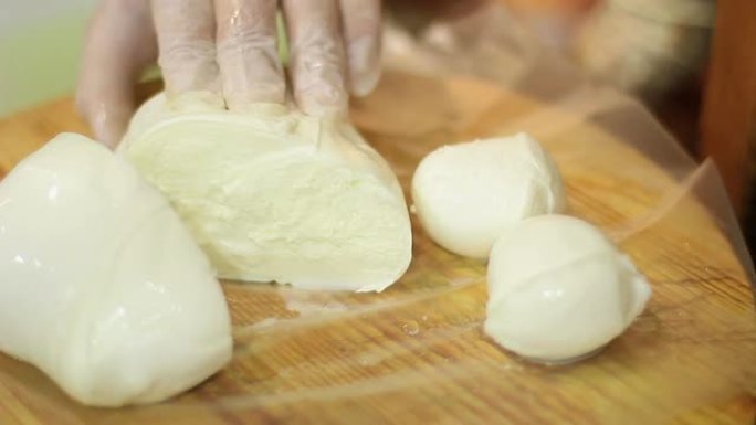 刀分割新鲜的马苏里拉奶酪-意大利食物
