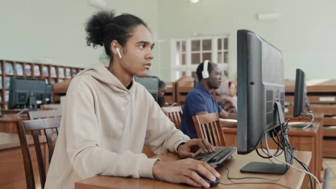 黑人男孩在图书馆使用计算机