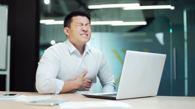 亚洲商人员工心脏病发作办公室工作人员患有严重的心脏疼痛。抱胸