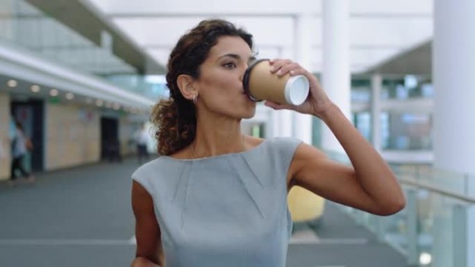 西班牙裔女商人在机场用智能手机走路在公司办公室发短信用手机打字喝咖啡成功的女高管在工作4k镜头