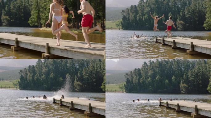 快乐的朋友在湖中跳下码头，在水中嬉水享受自由，在假期享受快乐的夏季冒险