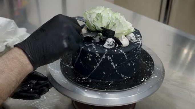 厨师顶部黑色喷枪涂磨砂糖霜蛋糕顶部两个真正的玫瑰银喷和可食用的巧克力头骨，卡拉维拉主题muertos