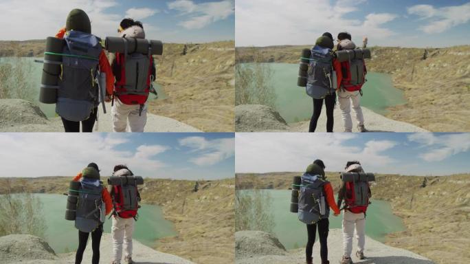 两名游客手牵着手来到湖边的背景图，大风天气