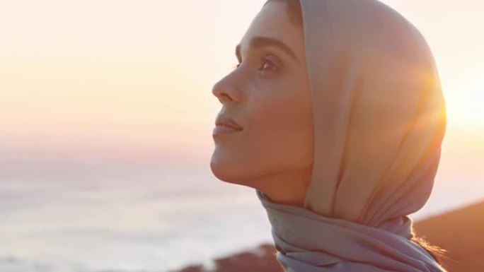 美丽的穆斯林妇女的肖像，看起来沉思，探索灵性，感觉和平，享受日落，戴着头巾