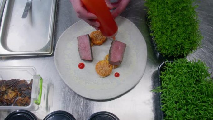 厨师将番茄酱和烤牛排倒在盘子上