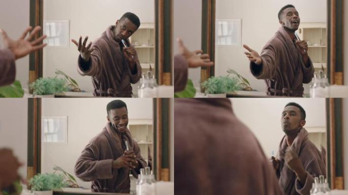 快乐的非洲裔美国男子在浴室照镜子跳舞，早上例行活动愉快，准备穿着浴袍享受积极的自我形象