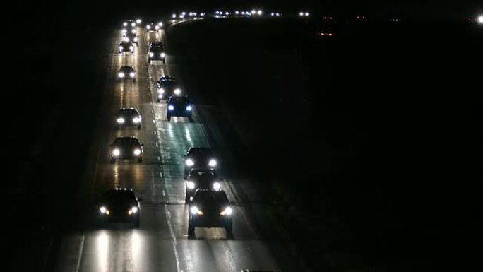 夜间在潮湿的高速公路上排长队的汽车