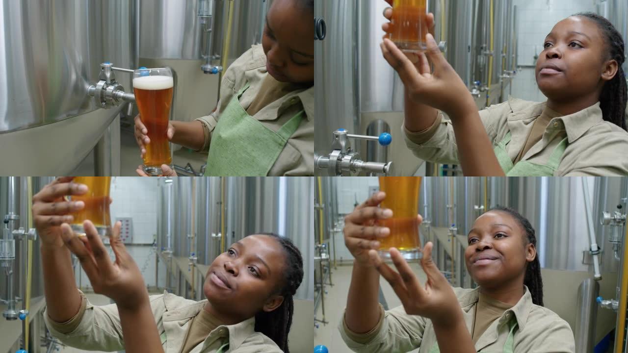 黑人女啤酒厂工人检查品脱新鲜啤酒
