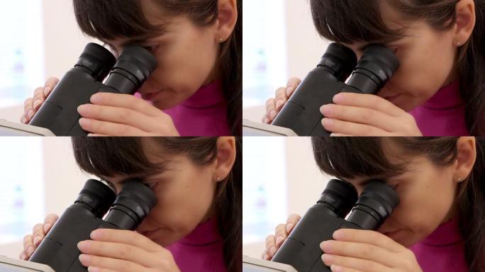 科学家女人用显微镜检查东西