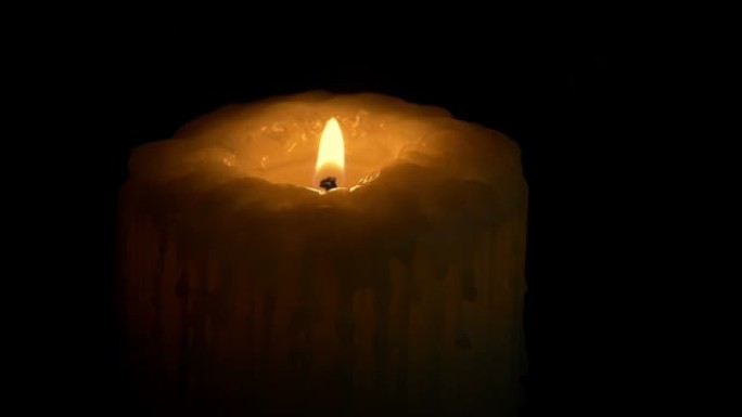 在黑暗中点燃一根大蜡烛并吹灭