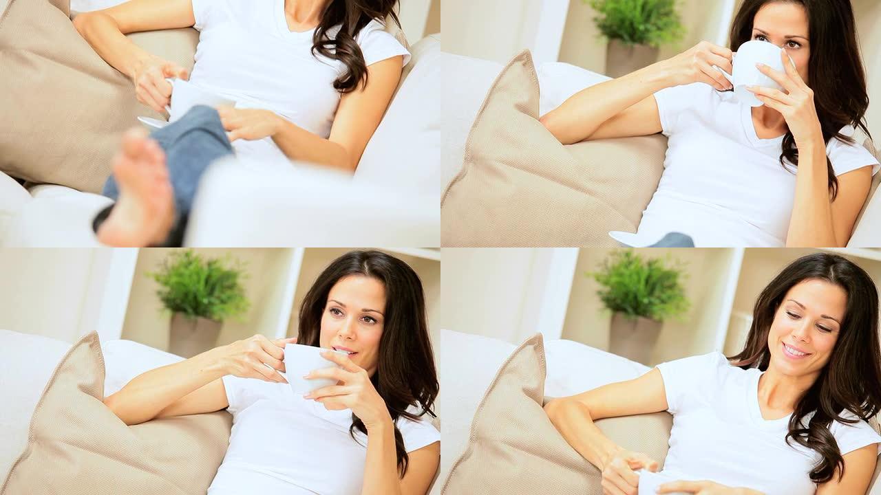 女性在家庭沙发上喝咖啡