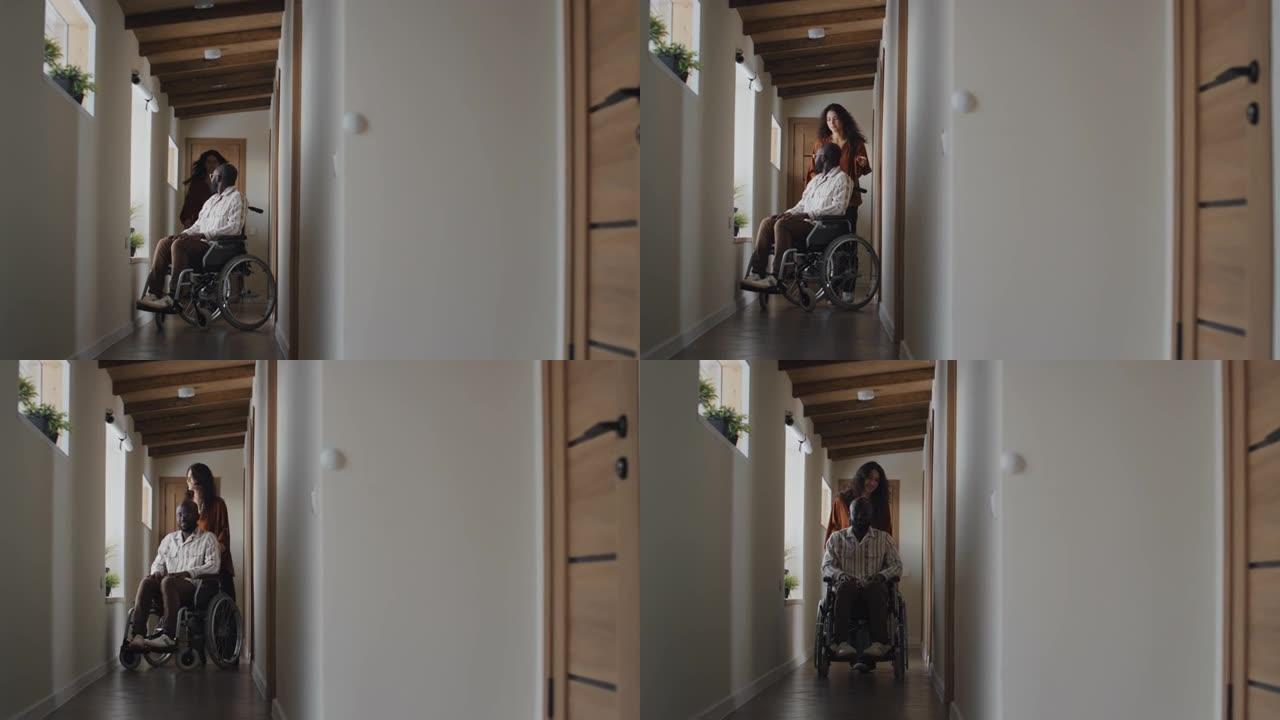 白人妇女驾驶着轮椅上的黑人男子沿着走廊走向摄像机