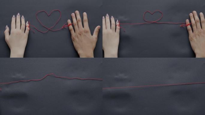 手的特写男人和女人用心形线绑在灰色背景上分离