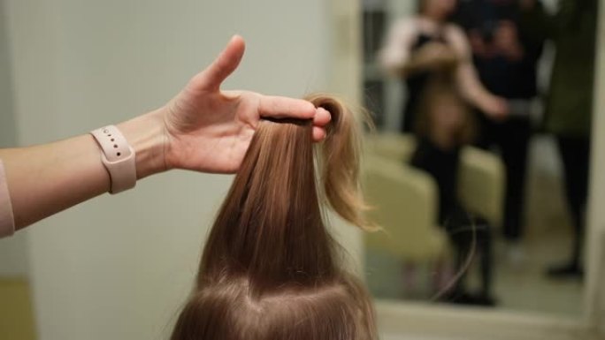 一个女人用梳子梳一个小女孩的头发