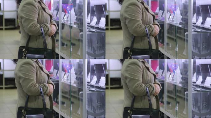 客户在电子产品商店中查看笔记本电脑的价格