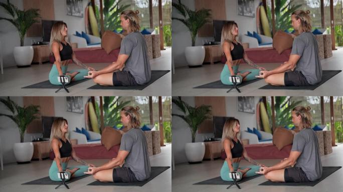 瑜伽夫妇禅坐姿势。伴侣瑜伽练习。人们在家练习。