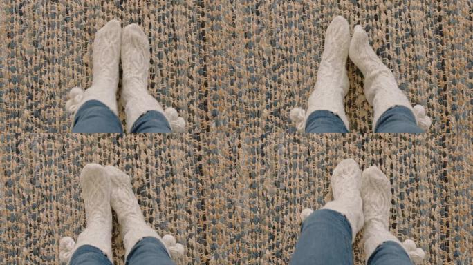 顶视图脚穿着舒适的袜子，在地毯上享受家里的温暖