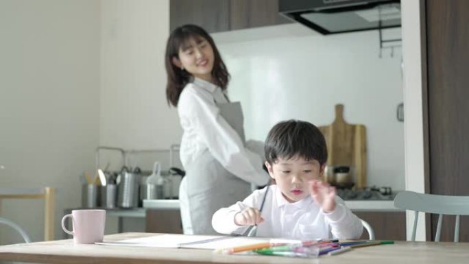 画画的孩子和做家务时照看的母亲