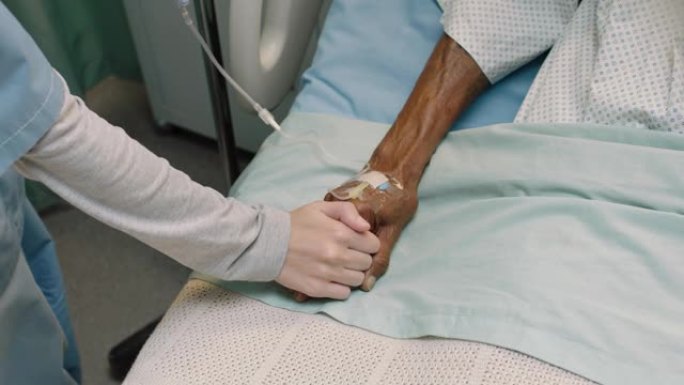 俯视图护士在病床上触摸老人的手表示对康复的老年患者的感情