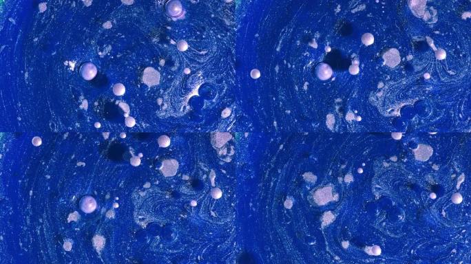 珍珠漆和气泡溶解的抽象液体蓝色漩涡的俯视图。油墨、球体、油。五颜六色的形状。详细的背景，漂亮的设计，