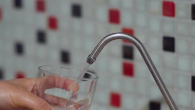 从净水器中填充水，用玻璃杯从水龙头中取水，从净水器中填充饮用水，