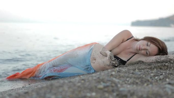 年轻女子躺在沙滩上晒太阳