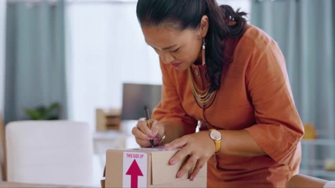 亚洲女性，在小型企业，物流或电子商务中写作和装箱以进行送货，在线订购或包装。快乐的女企业家用笔给货物