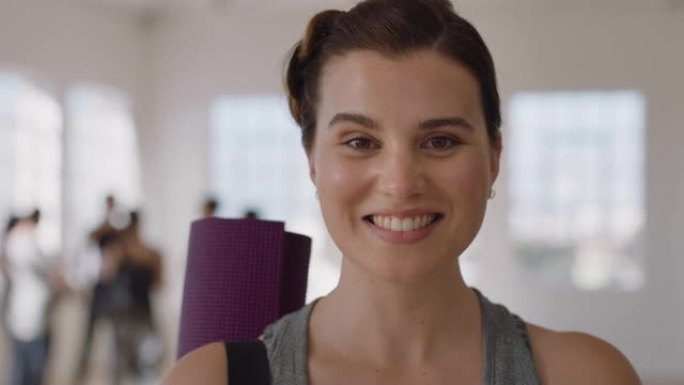 肖像美丽的白人妇女微笑着享受瑜伽课，在健身室练习健康的生活方式