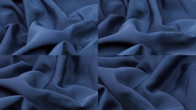 蓝色织物背景。蓝布波浪背景纹理。蓝色织物布纺织材料。