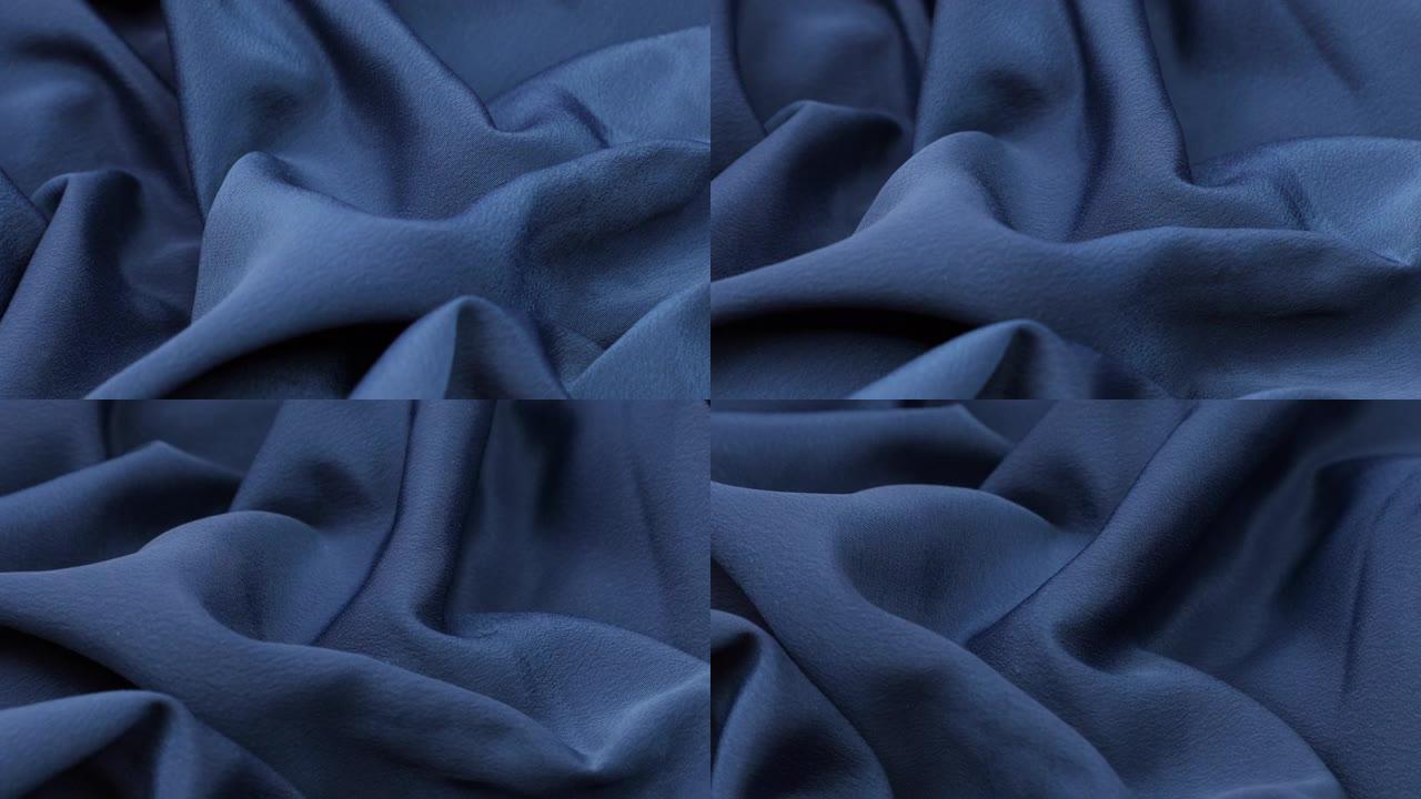 蓝色织物背景。蓝布波浪背景纹理。蓝色织物布纺织材料。