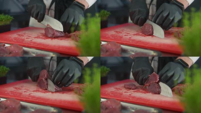 围裙上的男厨师在切菜板上切肉