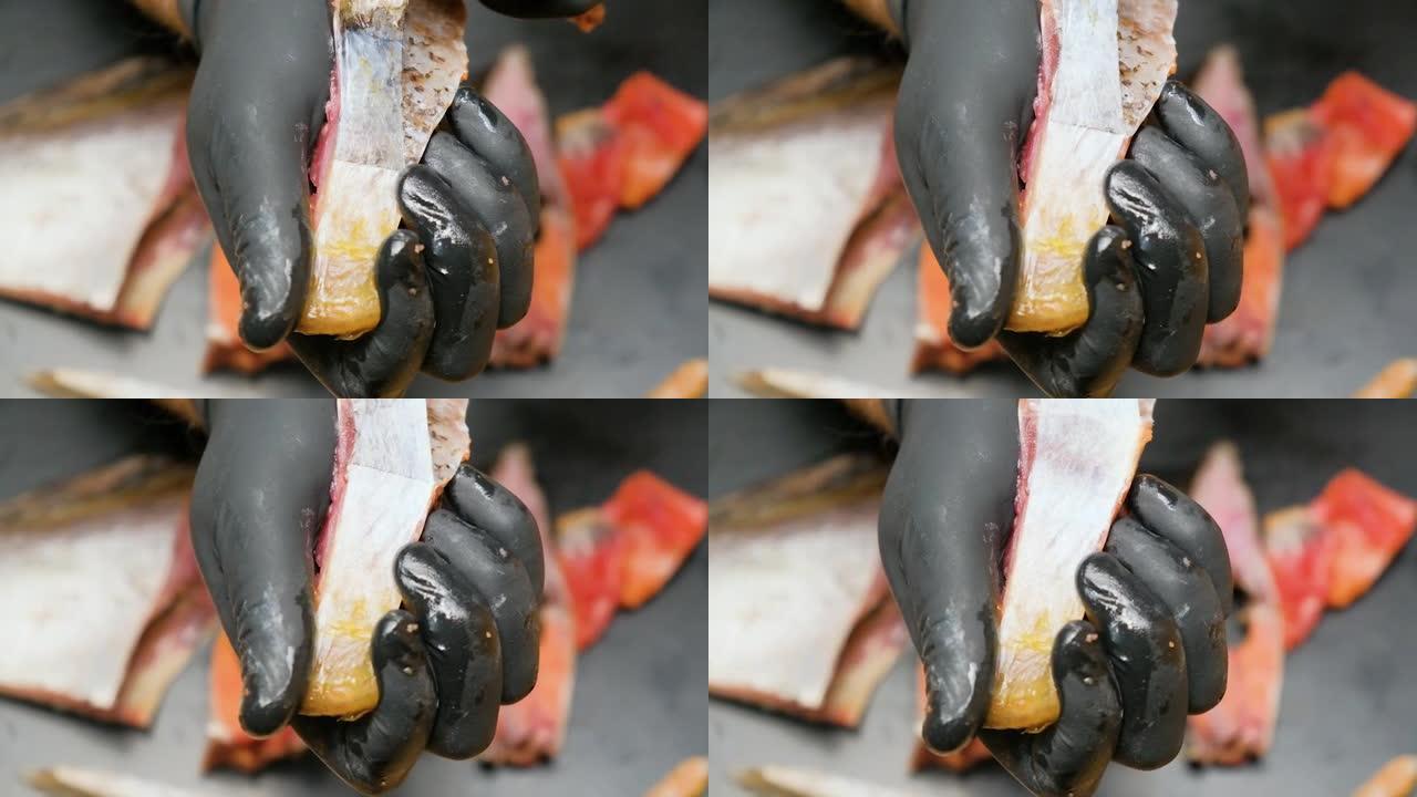 戴着黑色手套的厨师将干燥的皮肤蒙皮。特写。