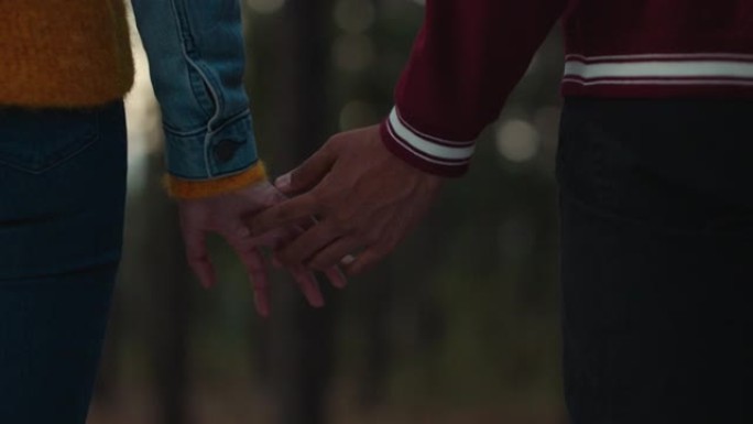 日落时分，十几岁的情侣在森林里牵手男朋友嬉戏地抱着女朋友小指分享森林里的浪漫联系快乐的年轻恋人