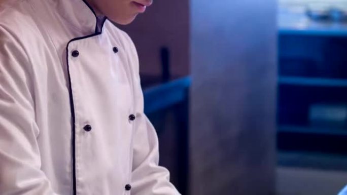 站在餐厅厨房的年轻集中厨师的垂直多莉镜头