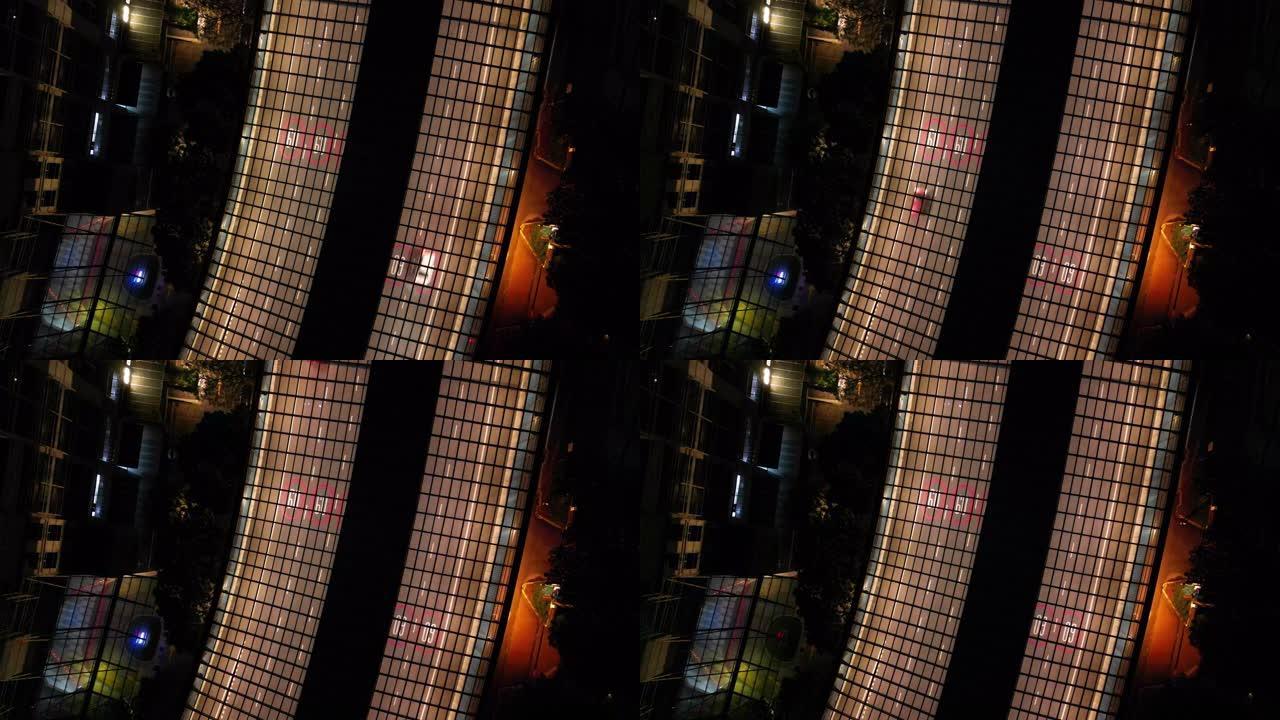 无人驾驶飞机的视角在住宅区的夜间冲刺高速公路上被电灯照亮