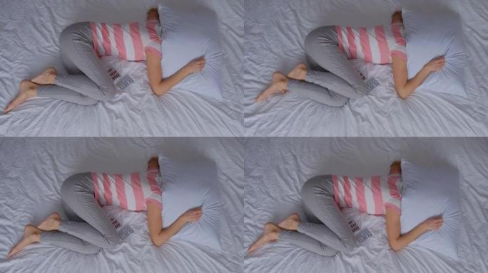 孤独而沮丧的孕妇躺在床上蜷缩成球。