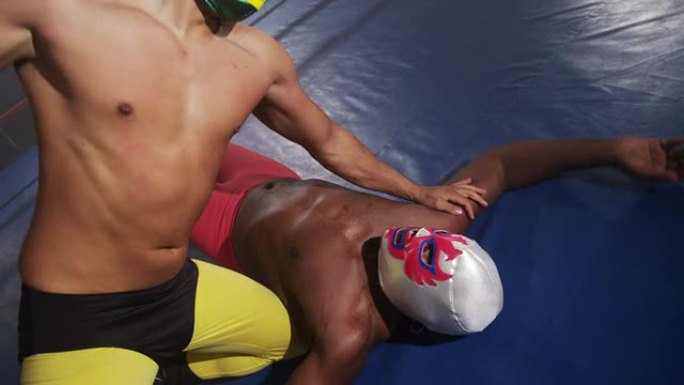 戴着面具的摔跤手在环，慢动作中战斗
