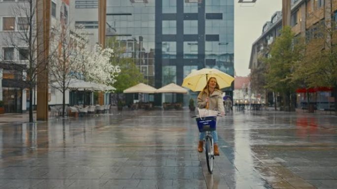 SLO MO年轻女子带黄伞在城市雨中骑自行车