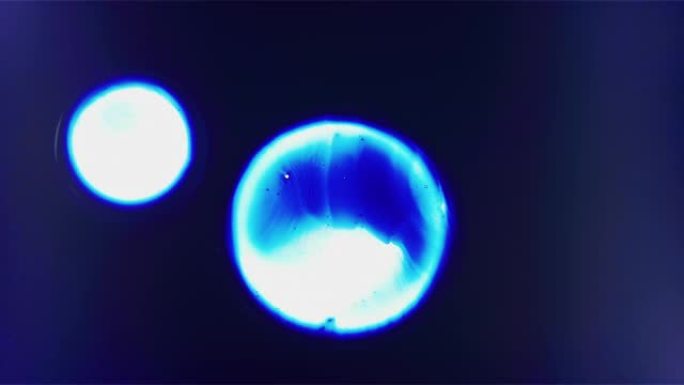 漂浮在空间合并背景中的三个蓝色细胞液滴