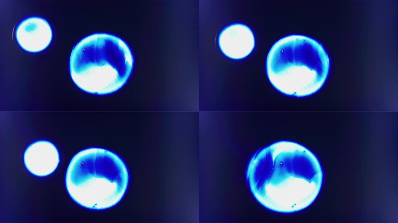 漂浮在空间合并背景中的三个蓝色细胞液滴