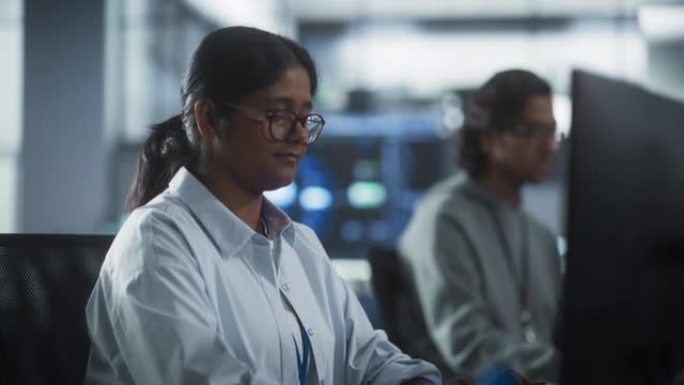 年轻的印度同事在电脑上工作，在工作场所聊天。聪明的女性和男性软件开发人员专注于编码和分析新技术功能