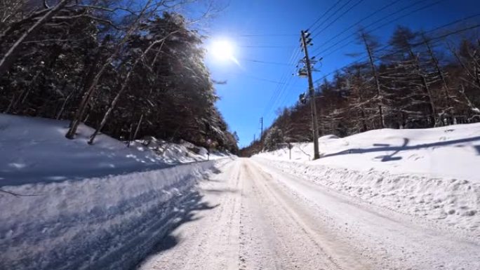 在冬季山区积雪覆盖的道路上行驶。驶向太阳