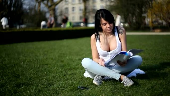 年轻漂亮的女人在公园学习