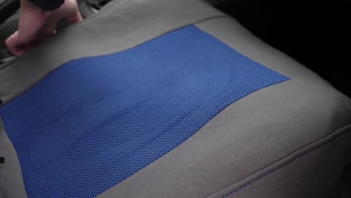 一名男子在汽车座椅上拉了一个布套。使用汽车配件的概念。