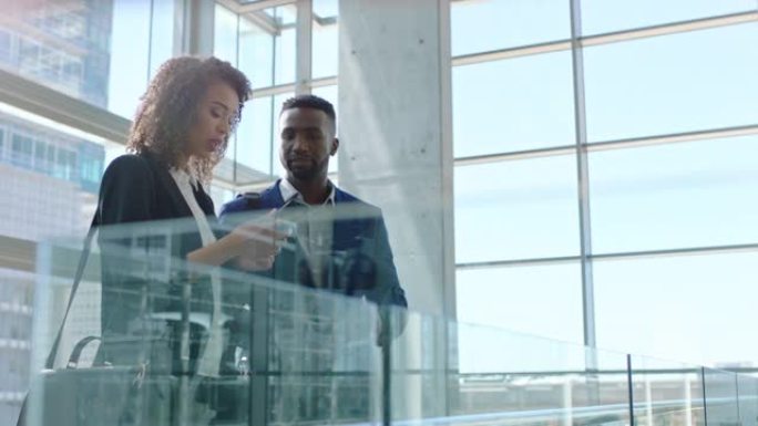 混血女商人使用智能手机与非洲裔美国商人同事聊天，讨论工作在公司办公室4k