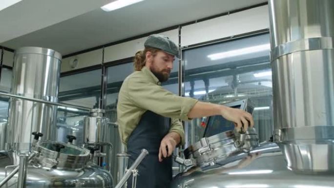 高加索男性技术员检查啤酒厂的啤酒制造过程