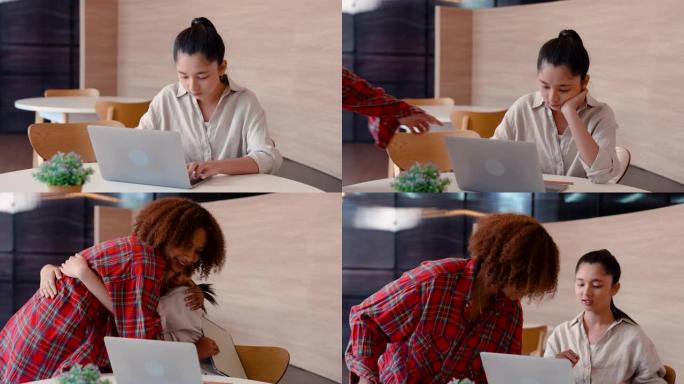 4K，年轻的亚洲女孩坐在笔记本电脑上研究，分开时间坐着等待朋友如期成对工作，朋友走进去她迅速站起来拥