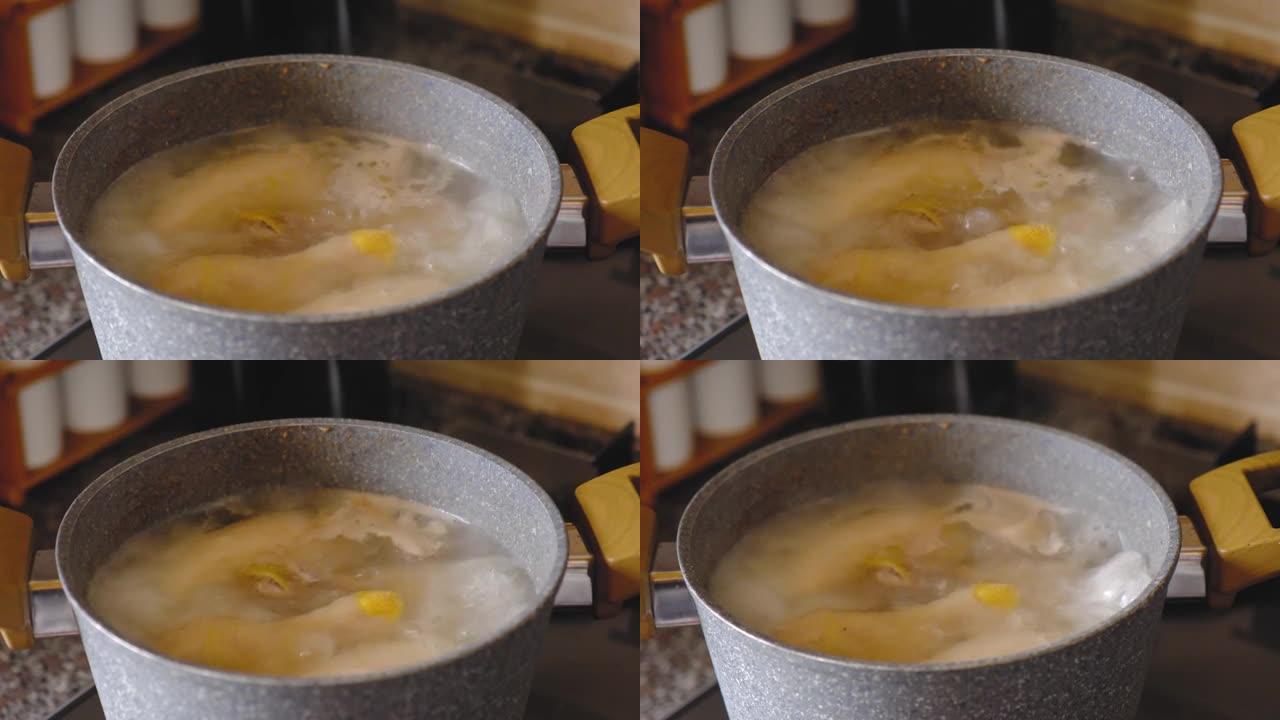 在锅里炖鸡肉。高汤在汤锅中煮沸，保健食品