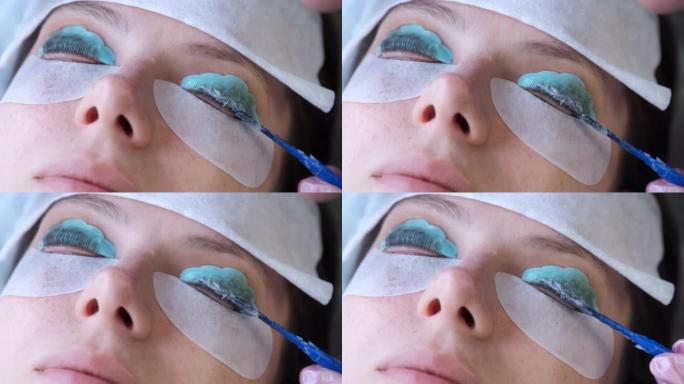 美容师在女人的睫毛上使用溶液来层压提升睫毛。