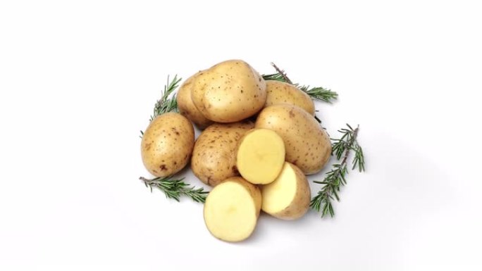 生鲜时令土豆堆整块和半块在果皮中，迷迭香草药轮作分离